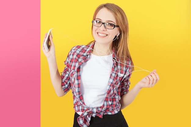 Foto mujer bailando con auriculares escuchando música en el teléfono inteligente