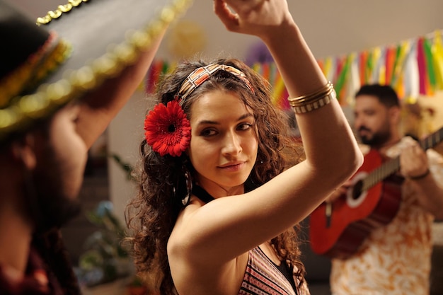 Foto mujer bailando con gerbera roja en el cabello