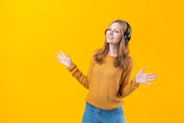 Mujer bailando música mientras escucha un reproductor de MP3 con auriculares con cable