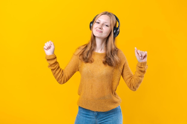 Mujer bailando música mientras escucha un reproductor de MP3 con auriculares con cable