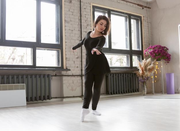 Mujer bailarina haciendo ejercicio en el estudio de danza