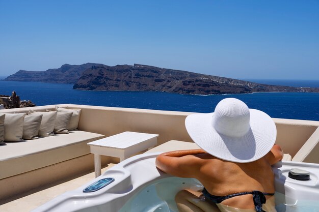 Foto mujer en un baño en oia, santorini, grecia