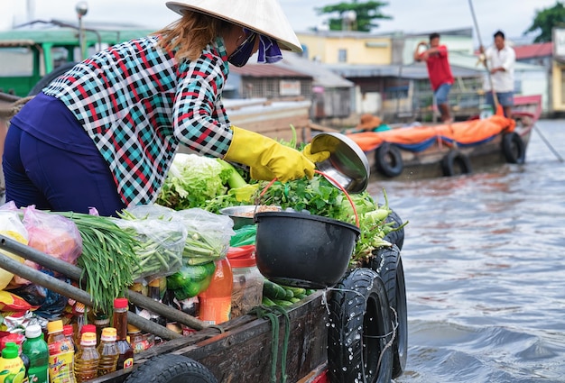 Mujer en un barco vendiendo verduras frescas en el mercado flotante en el delta del Mekong en Can Tho, en Vietnam