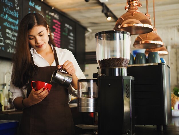 Mujer Barista haciendo una taza de café en el café.