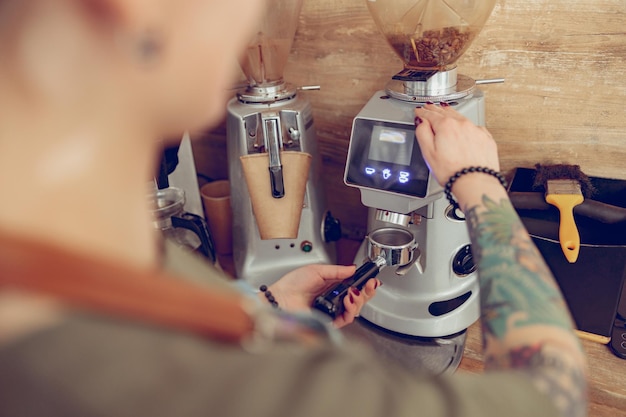 Mujer barista manos preparando café en la cafetería