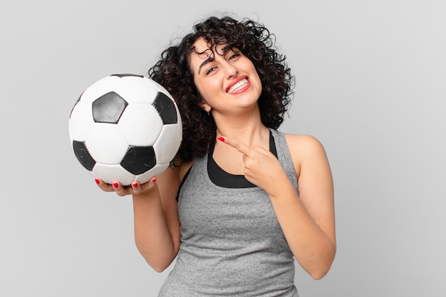 mujer bastante árabe con un balón de fútbol.