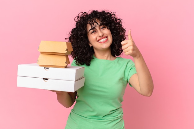 Foto mujer bastante árabe con cajas de comida rápida para llevar