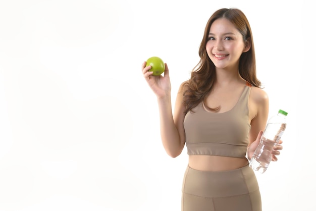 Mujer bastante asiática con manzana y agua sobre fondo blanco.