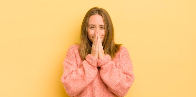 Mujer bastante caucásica feliz y emocionada sorprendida y asombrada cubriendo la boca con las manos riéndose con una expresión linda