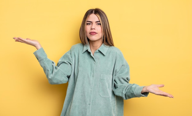 Mujer bastante caucásica que parece desconcertada, confundida y estresada, preguntándose entre diferentes opciones, sintiéndose insegura
