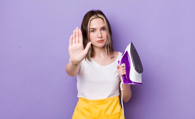 Foto mujer bastante caucásica que parece seria mostrando la palma abierta haciendo un gesto de parada concepto de hierro de mano