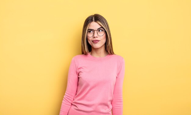 Mujer bastante caucásica que parece tonta y divertida con una expresión tonta bizca, bromeando y bromeando