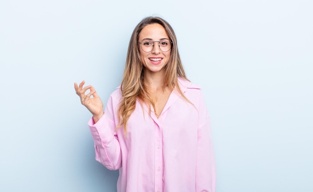 Mujer bastante caucásica que se siente feliz, sorprendida y alegre, sonriendo con actitud positiva, dándose cuenta de una solución o idea