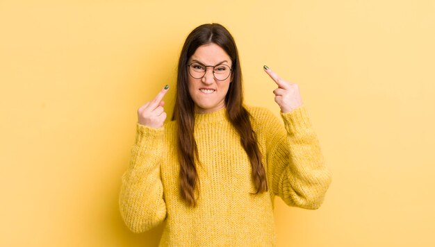 Mujer bastante caucásica que se siente provocativa, agresiva y obscena moviendo el dedo medio con una actitud rebelde