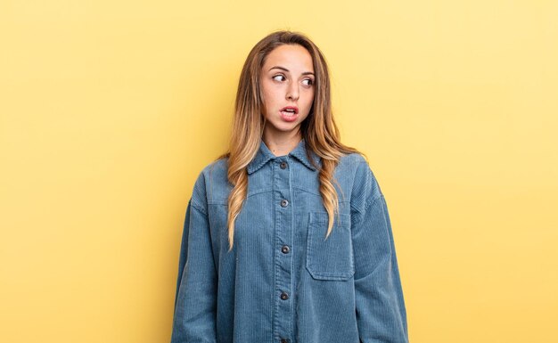 Mujer bastante caucásica que se siente sorprendida, feliz, asombrada y sorprendida, mirando hacia un lado con la boca abierta