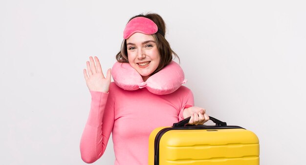 Mujer bastante caucásica sonriendo felizmente agitando la mano dándole la bienvenida y saludando el concepto de pasajero de vuelo