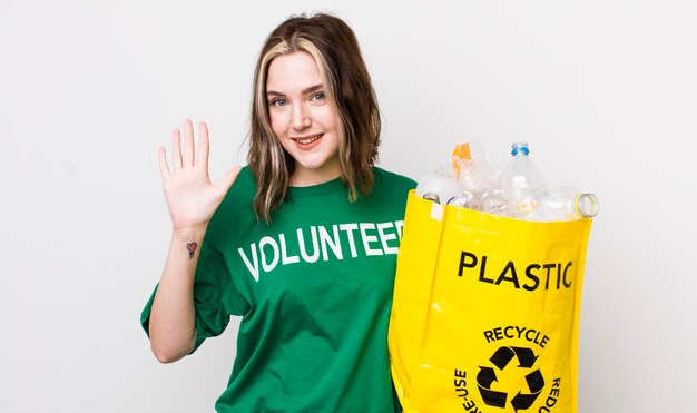 Mujer bastante caucásica sonriendo y luciendo amigable mostrando el concepto de ecología número cinco