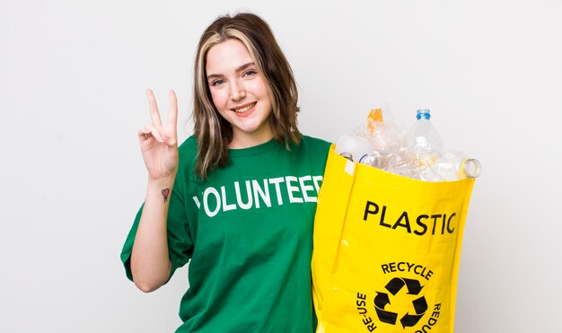 Mujer bastante caucásica sonriendo y luciendo feliz gesticulando victoria o concepto de ecología de paz