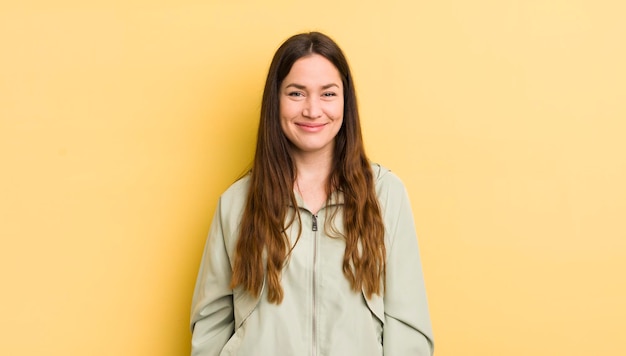 Mujer bastante caucásica sonriendo positivamente y con confianza luciendo satisfecha amistosa y feliz