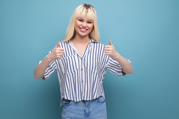 Mujer bastante europea enérgica positiva con camisa a rayas en el fondo del estudio