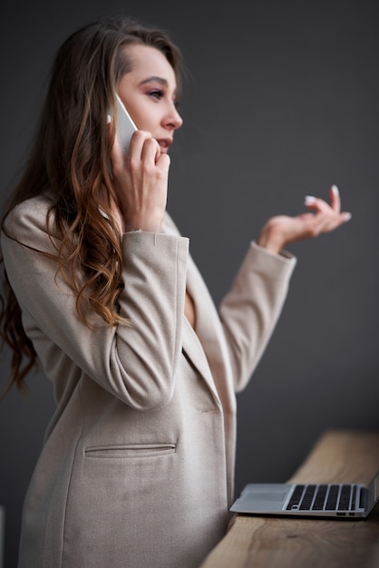 Mujer bastante joven de la belleza que usa la computadora portátil en café, mujer de negocios al aire libre del retrato, estilo inconformista, Internet, teléfono inteligente, oficina, Bali Indonesia, tenencia, mac OS,