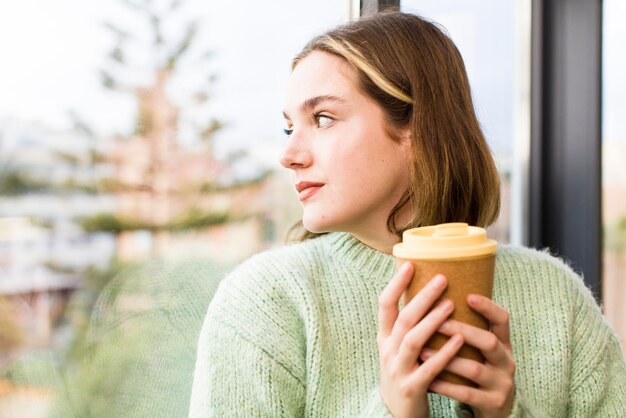 Mujer bastante joven con un café caliente en el diseño interior de la casa