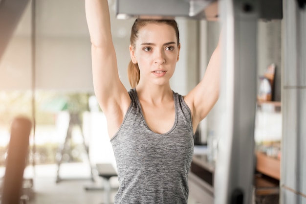 La mujer bastante joven del deporte es entrenamiento en gimnasio, forma de vida sana