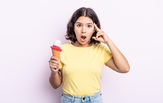 Mujer bastante joven que parece sorprendida, dándose cuenta de un nuevo pensamiento, idea o concepto. concepto de helado