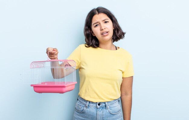 Mujer bastante joven que se siente desconcertada y confundida. concepto de jaula para mascotas