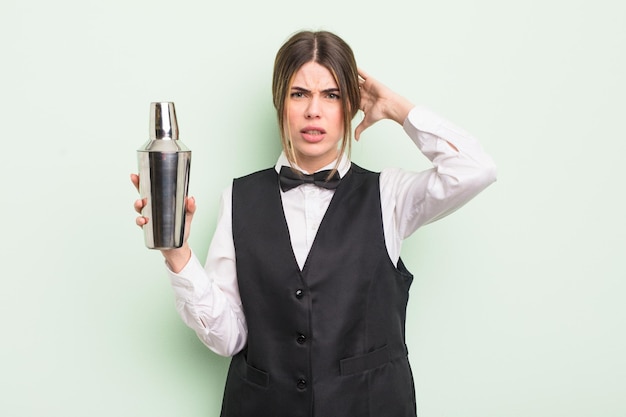 Mujer bastante joven que se siente estresada, ansiosa o asustada, con las manos en la cabeza. concepto de barman de cócteles