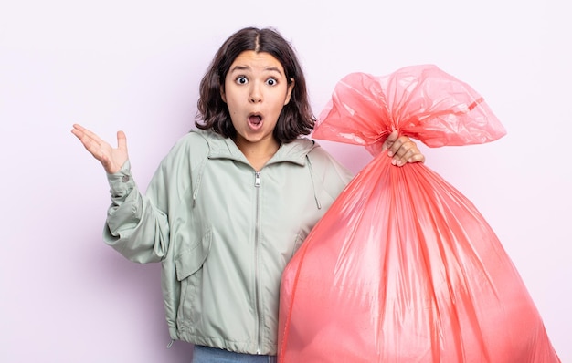 Mujer bastante joven que se siente extremadamente conmocionada y sorprendida. concepto de bolsa de basura