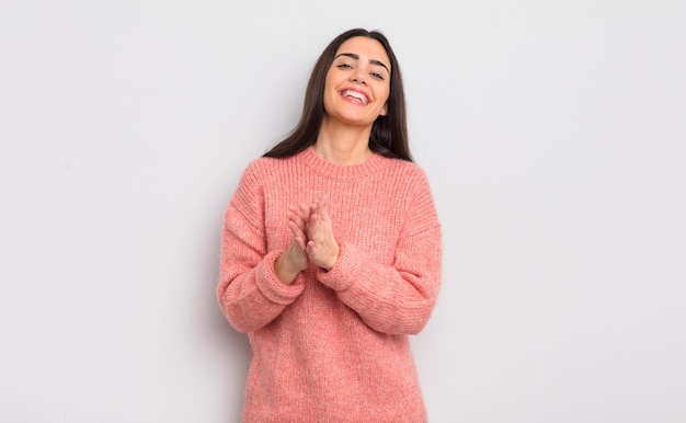 Mujer bastante joven que se siente feliz y exitosa, sonriendo y aplaudiendo, felicitando con un aplauso