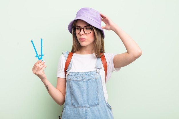 Mujer bastante joven que se siente perpleja y confundida rascándose el concepto de estudiante de cabeza