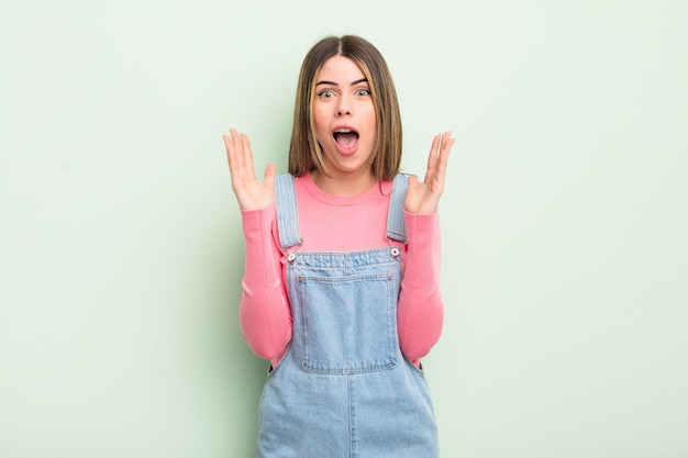 Mujer bastante joven que se siente sorprendida y emocionada, riendo, sorprendida y feliz por una sorpresa inesperada