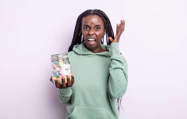 Mujer bastante negra gritando con las manos en el aire. concepto de caramelos de gelatina