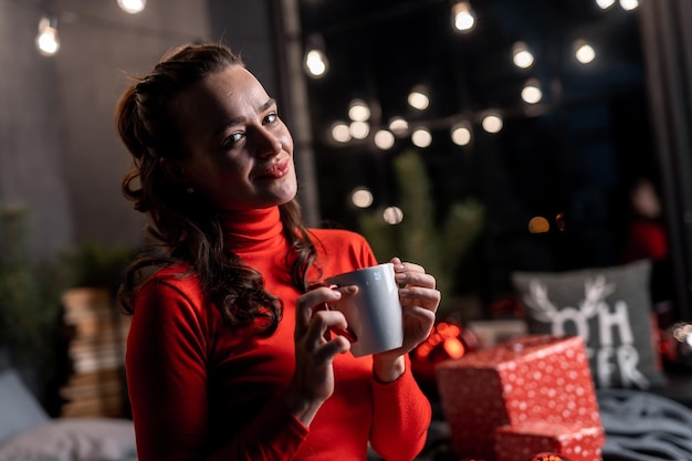 Mujer bastante soñadora con árbol de navidad Retrato de joven celebrando el año nuevo