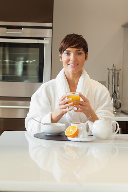 Mujer en bata de baño con desayuno saludable