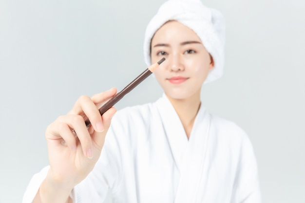 Mujer en bata de baño con maquillaje