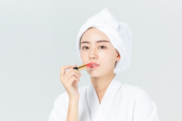 Mujer en bata de baño con maquillaje