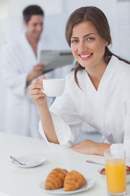 Mujer con una bata desayunando