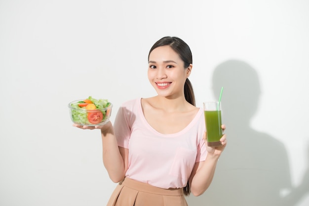 Mujer con batidos de desintoxicación verde, ensalada en recipiente de vidrio aislado. Nutrición adecuada, comida vegetariana, estilo de vida saludable, concepto de dieta. Área para copiar espacio