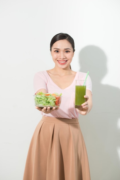 Mujer con batidos de desintoxicación verde, ensalada en recipiente de vidrio aislado sobre fondo blanco. Nutrición adecuada, comida vegetariana, estilo de vida saludable, concepto de dieta. Área para copiar espacio