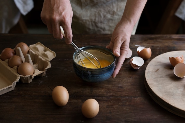 Mujer batiendo huevos en una masa