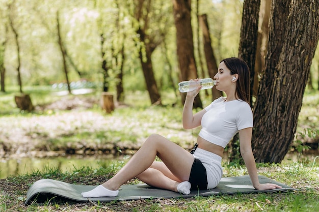 Mujer bebe agua después del deporte