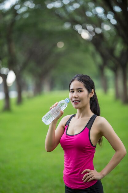 la mujer bebe agua del ejercicio.