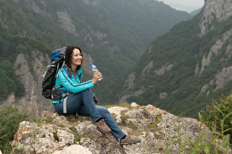 Mujer bebe agua en las montañas.