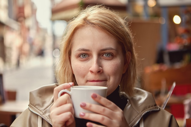 Mujer bebe café en la mesa en el café de la calle en estambul