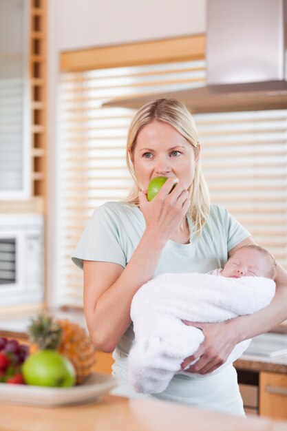 Mujer con bebé en su brazo con una manzana
