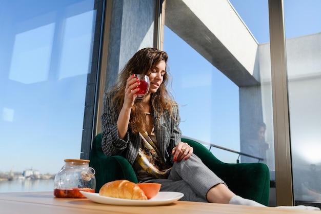 Mujer bebe té en el interior de una casa moderna