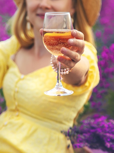 Una mujer bebe vino en un campo de lavanda Enfoque selectivo